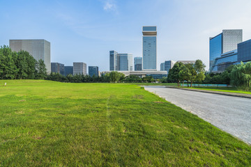 cityscape and skyline of suzhou from meadow in park
