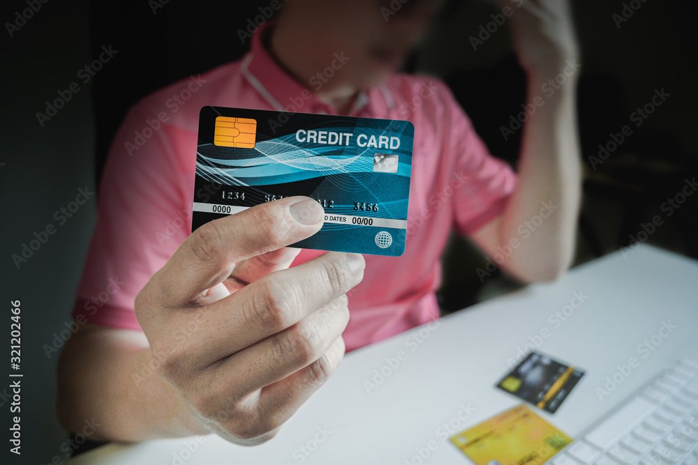 Poster man paying with credit cards on computer at home.