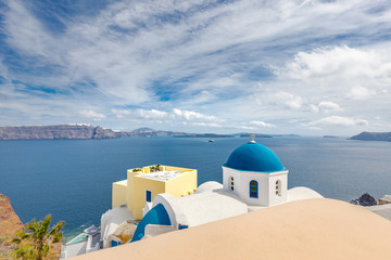 Fototapeta na wymiar Greek church with blue dome near the sea in Oia town, Santorini island, Greece