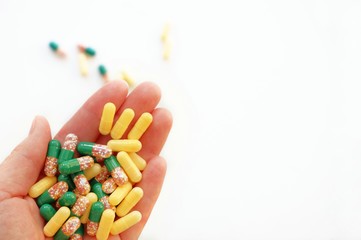 Multi-colored medical capsules, medicine closeup in hand on a white background. Cure Concept, healthcare, vitamins, medication. Top view with copy space for text.