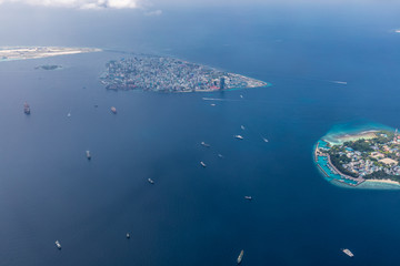 Fototapeta na wymiar Male island, capital of Maldives with boats and ships. Amazing aerial landscape, exotic travel destination