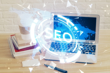 Multi exposure of table with computer and seo drawing hologram. Search optimization concept.