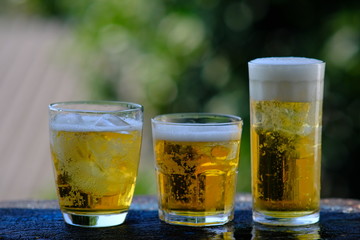 glass of beer with ice on wooden table
