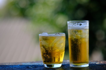 glass of beer with ice on wooden table