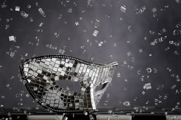 Maschera d'argento sopra la scacchiera bianca e nera con coriandoli  e cristalli