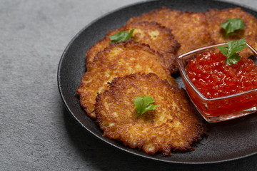 Crispy potato pancakes with red caviar. Potato pancakes fried in butter. Stack of potato fritters 