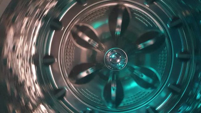 Stainless steel washing machine drum turning spin cycle, futuristic industrial look of modern machinery