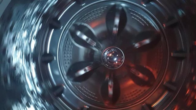 Stainless steel washing machine drum turning spin cycle, futuristic industrial look of modern machinery