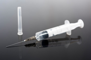 Vaccination time. Vaccine in vial with syringe on clock background. Prevention immunization illness.