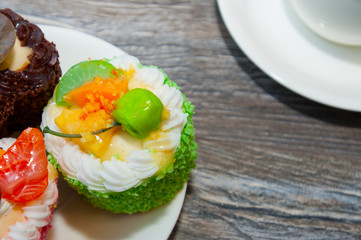 Mini colored sweet cakes on white plate. Delicious Dessert