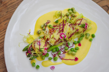 Grilled scallops garnished with green peas and shredded red cabbage top view