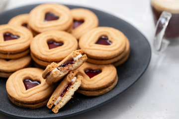 cookies with hearts on dark plate on ceramic background