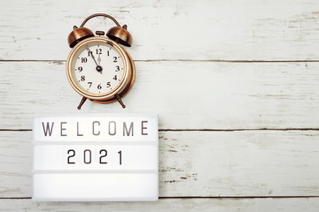 Welcome 2021 text in light box with space copy on wooden background