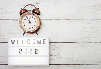 Welcome 2022 text in light box with space copy on wooden background