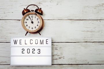 Welcome 2023 text in light box with space copy on wooden background