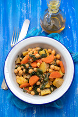 chick-pea with carrot and spinach on white bowl on blue wooden backgeound