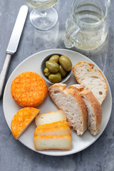 appetizer cheese with bread and olives on dish