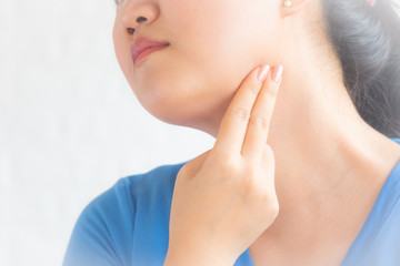 Throat pain. Woman holding her inflamed throat,sick woman with sore throat; portrait of woman suffering from cold, flu, sickness with sore throat inflammation, Medical concept.