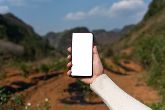 A Woman's Hand Holding A Blank Mobile Phone Outdoors In Spring Mountains