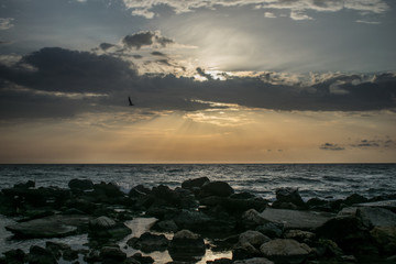 a beautiful sunrise on the sea. Boat and rocks near the shore. a dramatic dawn