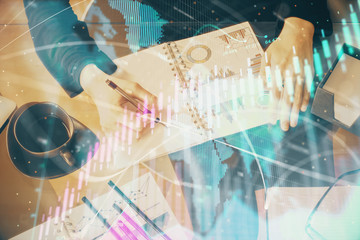 Multi exposure of hands making notes with forex chart huds. Stock market concept.