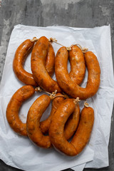portuguese smoked sausages alheira on paper wooden background