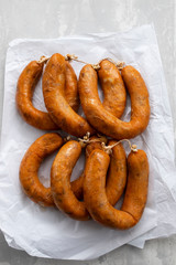 portuguese smoked sausages alheira on paper wooden background