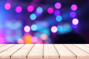 wood table with abstract bokeh of concert light background 
