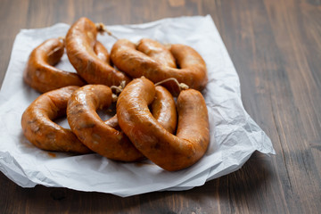 portuguese smoked sausages alheira on paper wooden background