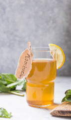 Kombucha or cider fermented drink. Cold tea beverage with beneficial bacteria, cinnamon, lemon on concrete  background side view with copyspace. For healthy nutrition.