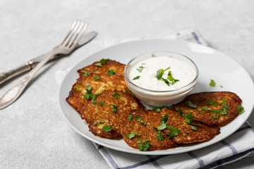Crispy potato pancakes with yogurt sauce. Potato pancakes fried in butter. Stack of potato fritters