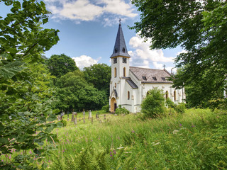 Fototapeta na wymiar Church of st. John of Nepomuk and Graveyard, Zadni Zvonkova, Czech Republic. 15th of July 2019. Neo-Gothic building in an abandoned border village with a troubled history.