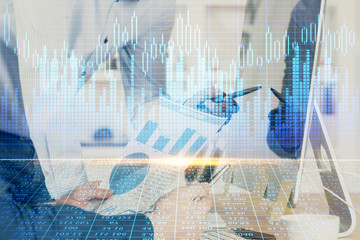 Obraz premium Double exposure of chart with businessman typing on computer in office on background. Concept of hard work.