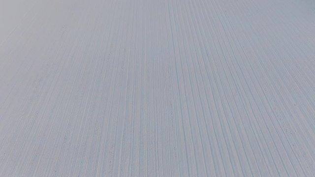 Aerial drone view of Tanaro river and snowy fields