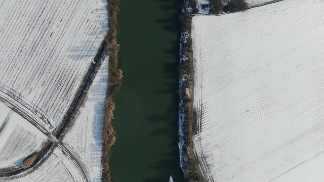 Aerial drone view of Tanaro river and snowy fields