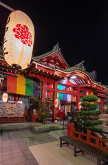 Buddhist Tokudaiji temple in the Ameyoko street of Tokyo illuminated by paper lanterns at night.