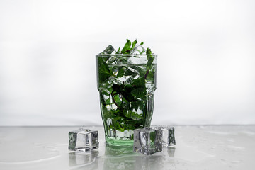 ice and mint fall in a cocktail spray. Rum with mint and ice in a glass.