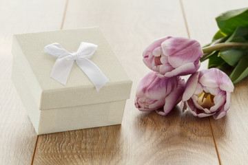 Gift box and flowers on wooden boards.