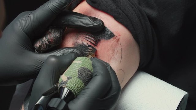 Man tattooist getting tattoo of snake, closeup