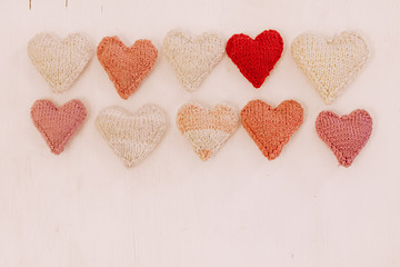 Obraz premium Hand made knitted heart on white wooden background. Valentine's day card with woolen heart and free space. Romantic sign.Hand made knitted heart on white wooden background. Valentine's day card with w