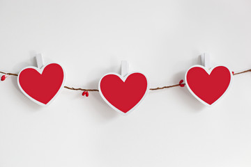 Handmade Valentine's Day garland. Valentine concept, on white background. Garland of wooden red...