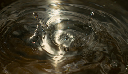 water drop splash in a glass. The water droplet is shaped like a tower. Metallic color- mercury