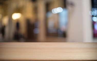 Fototapeta premium Empty dark wooden table in front of abstract blurred bokeh background of restaurant . can be used for display or montage your products.Mock up for space.