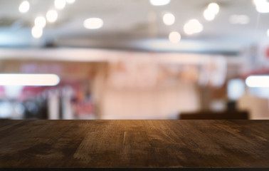 Empty dark wooden table in front of abstract blurred bokeh background of restaurant . can be used for display or montage your products.Mock up for space.