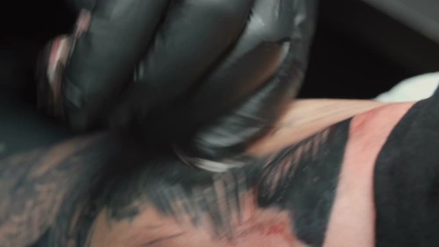 Tattooist getting black tattoo of snake in studio