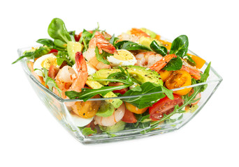 Salad with avocado, shrimp, fresh cherry tomatoes and arugula in glass bowl isolated on white
