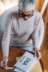 Senior Woman Preparing DNA Genetic Test Kit