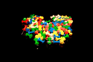 Multicolor Plastic Head Push Pins Thumbtacks isolated on black with reflections
