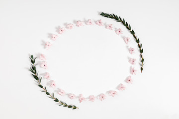 Modern composition of pink flowers and eucalyptus. Pattern made of eucalyptus branches and leaves, flowers on white background. Flat lay, top view, copy space