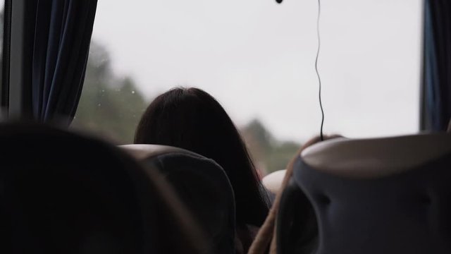 The girl looks through the bus window